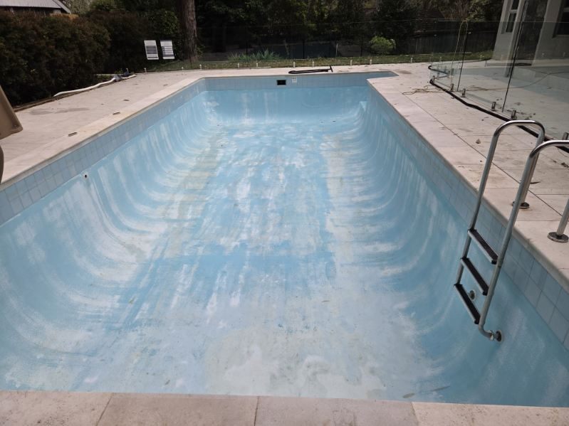A prepared pool surface with the first coat of paint going on